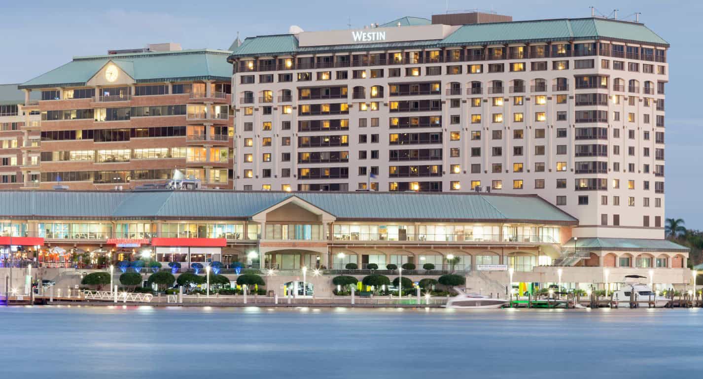 Luxury hotel at westin waterfront in fort lauderdale during SOF Week event, modern high-rise building with illuminated windows by the water.